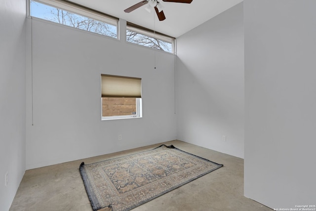 spare room with a towering ceiling and ceiling fan