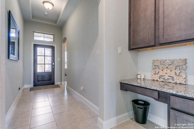 tiled foyer entrance with a tray ceiling