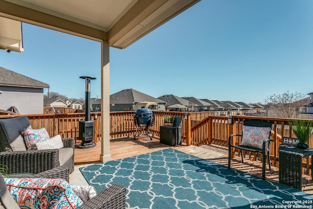 wooden deck featuring area for grilling and an outdoor living space