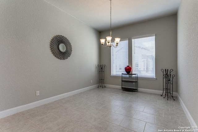 tiled empty room with an inviting chandelier