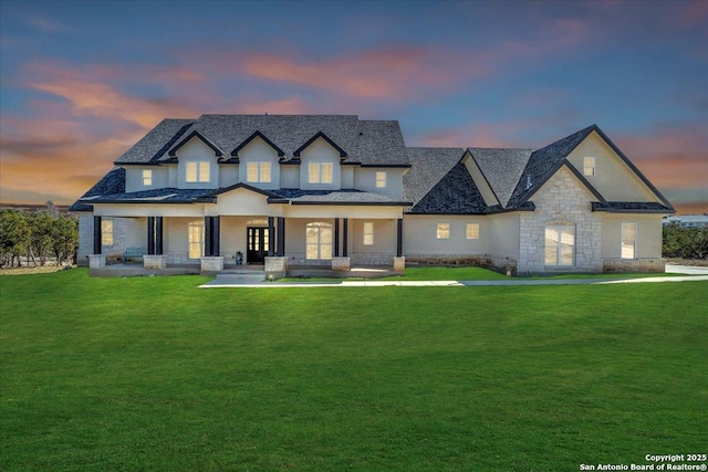 view of front of home featuring covered porch and a lawn