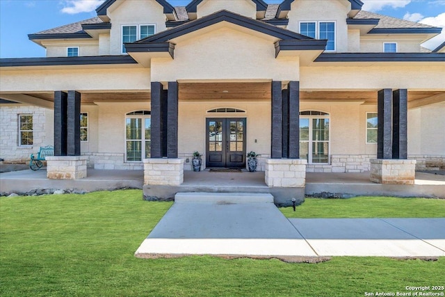 entrance to property featuring a lawn, french doors, and covered porch