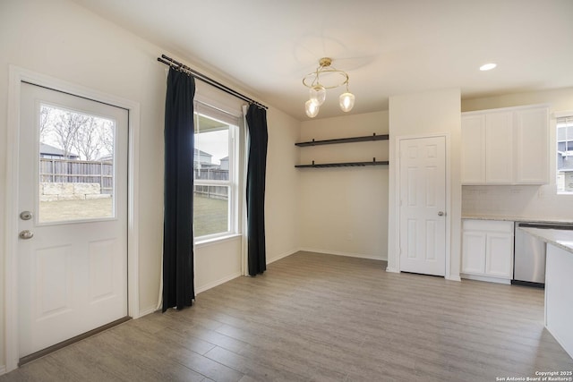 unfurnished dining area with light wood-type flooring and a wealth of natural light