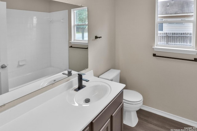 full bathroom with hardwood / wood-style flooring, vanity, toilet, and bathing tub / shower combination