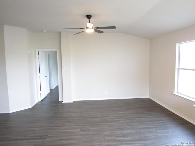 empty room with vaulted ceiling, dark hardwood / wood-style floors, and ceiling fan