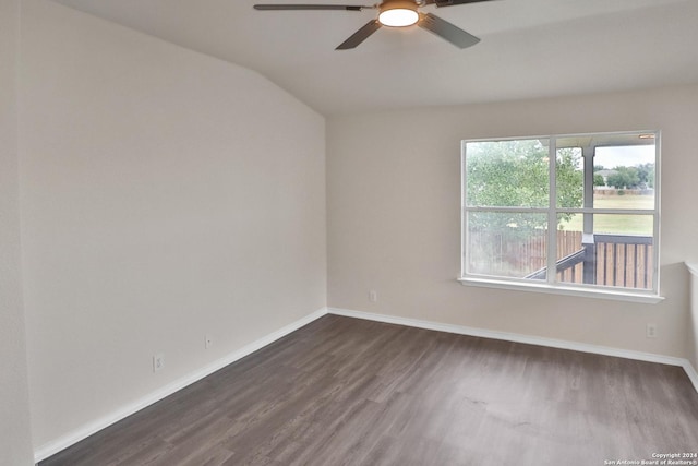 empty room with ceiling fan, dark hardwood / wood-style floors, and vaulted ceiling