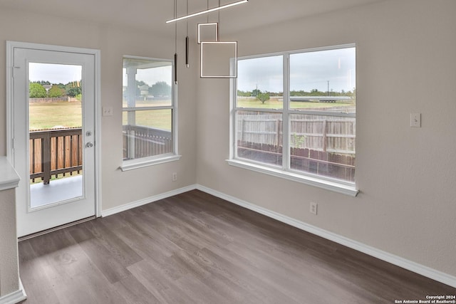 unfurnished dining area featuring dark hardwood / wood-style floors