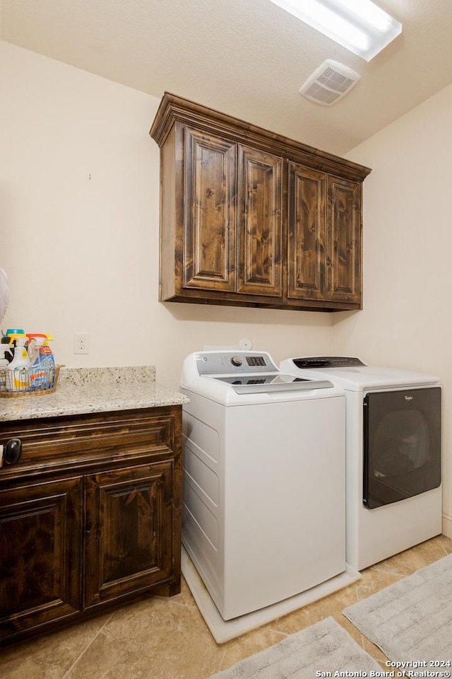 laundry room featuring cabinets and washer and clothes dryer