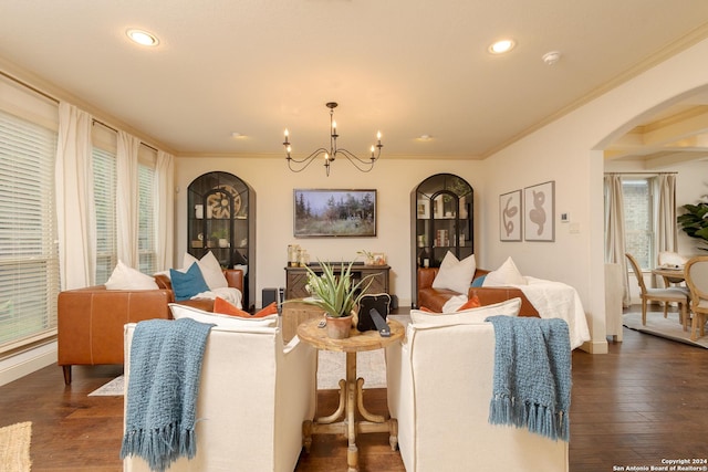 living room featuring crown molding, dark hardwood / wood-style floors, and an inviting chandelier