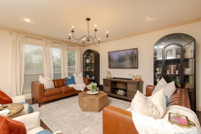 living room featuring ornamental molding, a notable chandelier, and light hardwood / wood-style floors