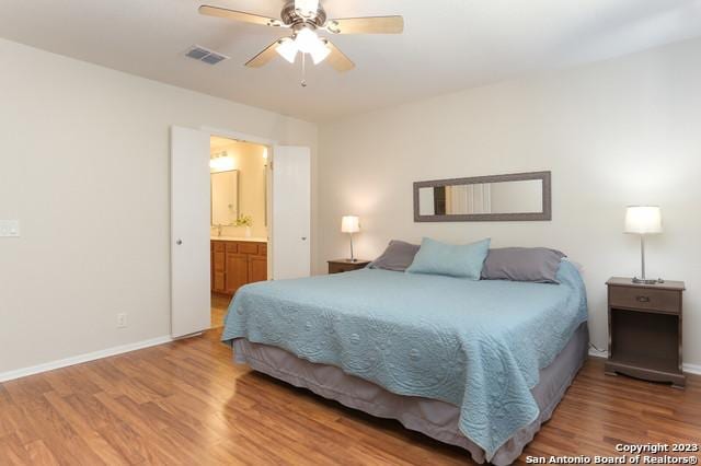 bedroom featuring connected bathroom, hardwood / wood-style floors, and ceiling fan