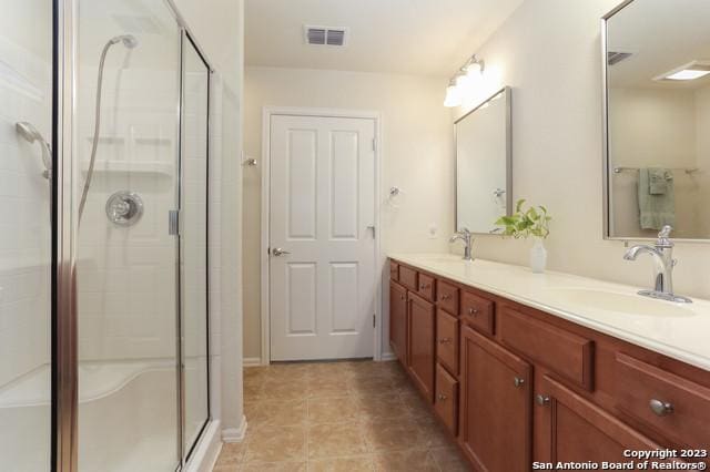 bathroom with vanity and a shower with door