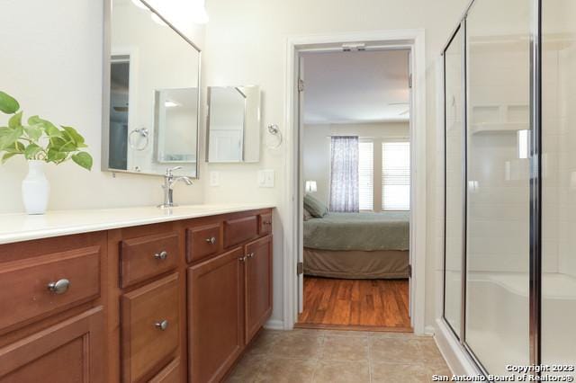 bathroom with tile patterned flooring, vanity, and a shower with shower door