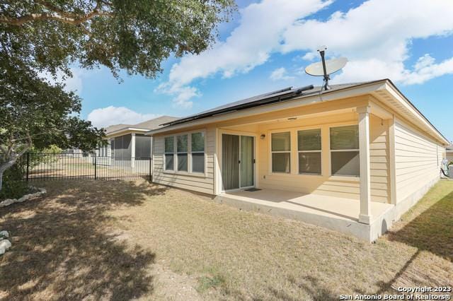 rear view of house with a patio and a lawn