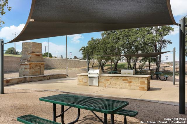 view of community with exterior kitchen and a patio