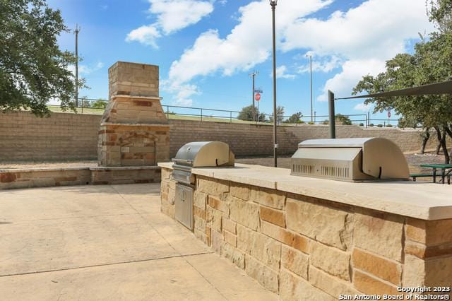 view of patio featuring an outdoor kitchen and a grill