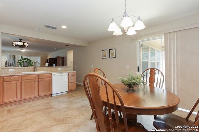 dining space featuring sink and a chandelier