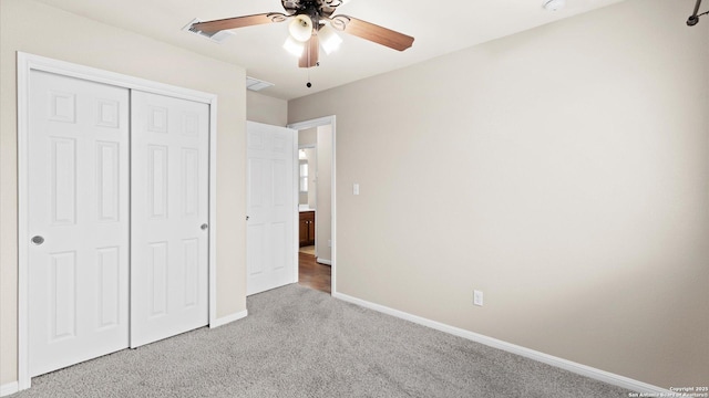 unfurnished bedroom with ceiling fan, carpet flooring, and a closet