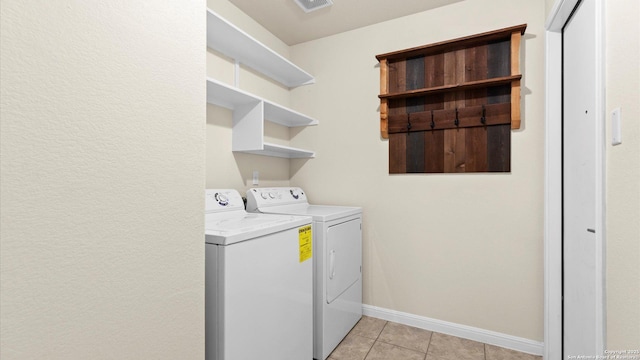 clothes washing area featuring light tile patterned floors and independent washer and dryer