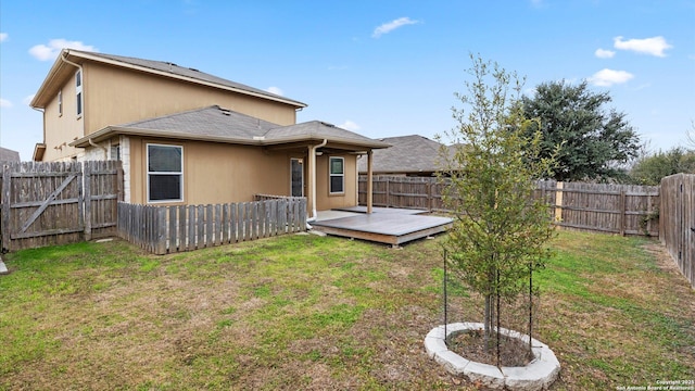 back of property with a wooden deck and a yard