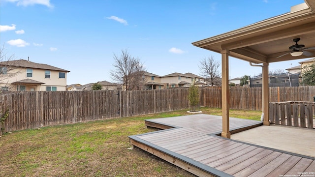 view of yard with a wooden deck and ceiling fan