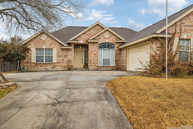 ranch-style house featuring a garage and a front lawn