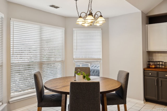 dining area featuring light tile patterned floors and a notable chandelier