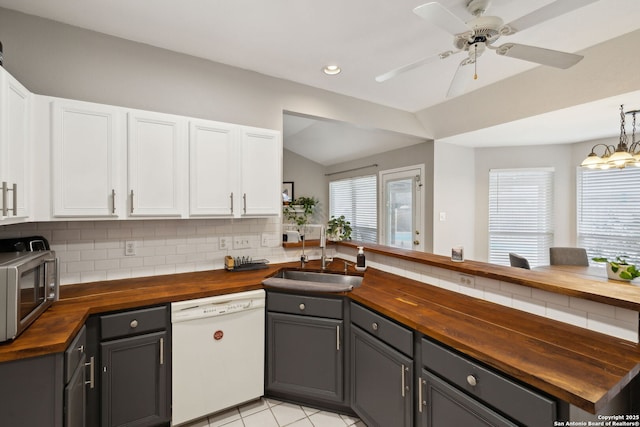 kitchen featuring dishwasher, sink, white cabinets, wooden counters, and decorative backsplash