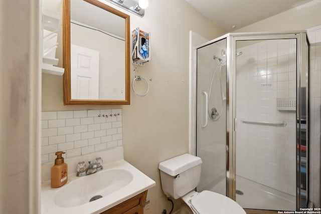 bathroom with vanity, an enclosed shower, decorative backsplash, and toilet