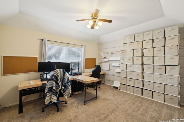 carpeted office space featuring lofted ceiling, a raised ceiling, and ceiling fan