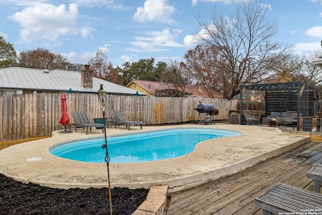 view of pool with a grill, a pergola, and a deck