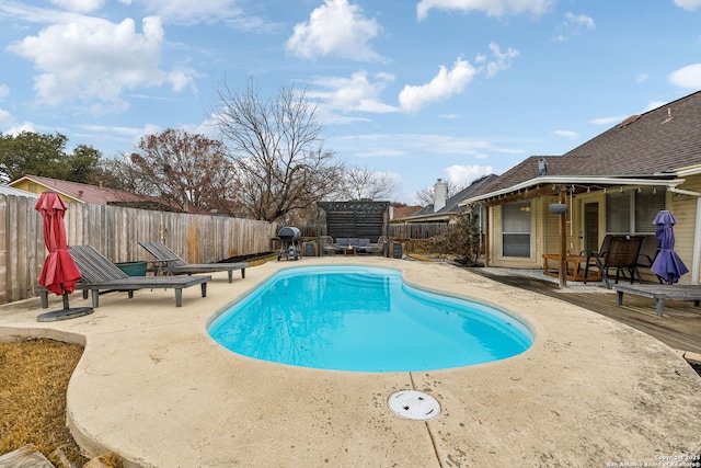 view of swimming pool featuring a grill and a patio