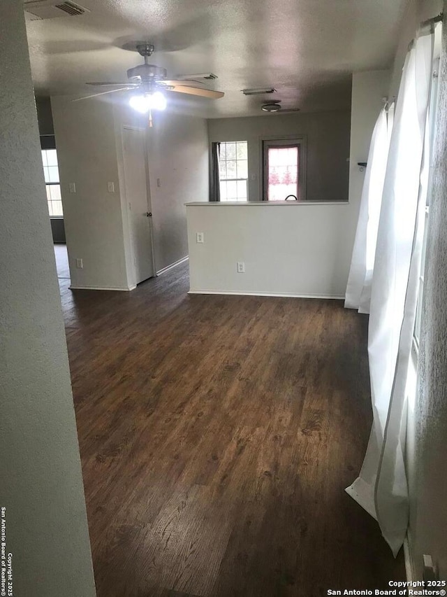 empty room with ceiling fan and dark hardwood / wood-style floors