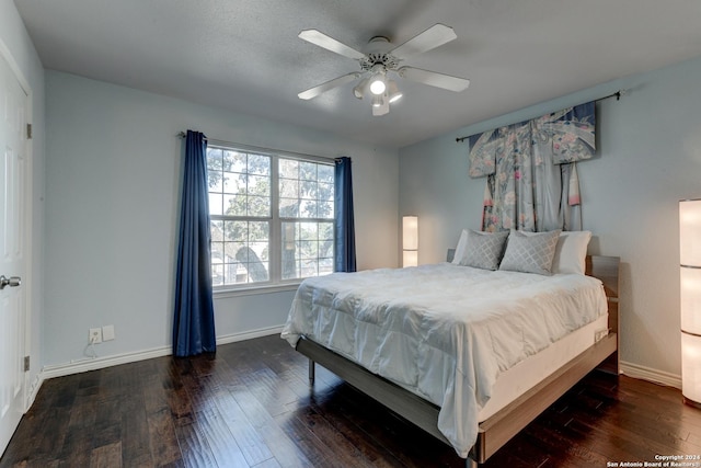 bedroom with white refrigerator, dark hardwood / wood-style floors, and ceiling fan