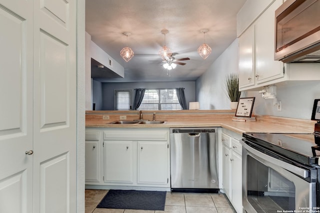 kitchen featuring sink, white cabinetry, light tile patterned floors, ceiling fan, and stainless steel appliances