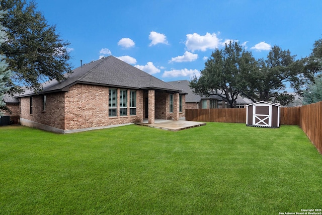 rear view of house with a shed, a patio, and a lawn