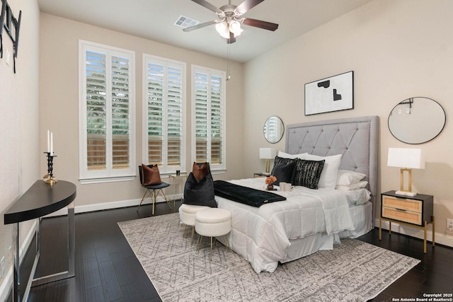 bedroom featuring dark wood-type flooring, ceiling fan, and multiple windows