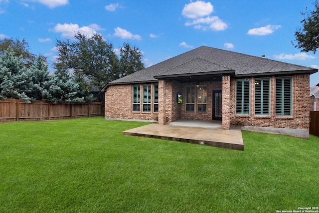 rear view of property with a patio and a lawn