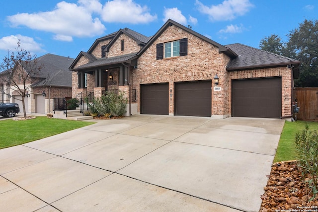 craftsman inspired home featuring a garage and a front lawn