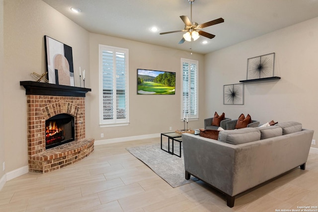 living room with a brick fireplace, light hardwood / wood-style floors, and ceiling fan