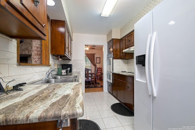 kitchen with ceiling fan, white appliances, sink, and decorative backsplash