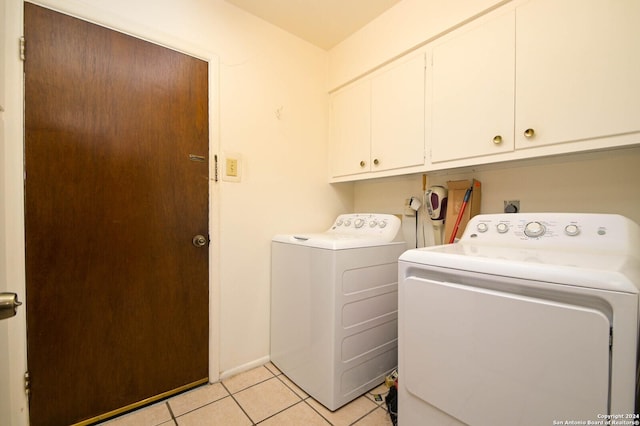 laundry room featuring light tile patterned flooring, cabinets, and washer and dryer