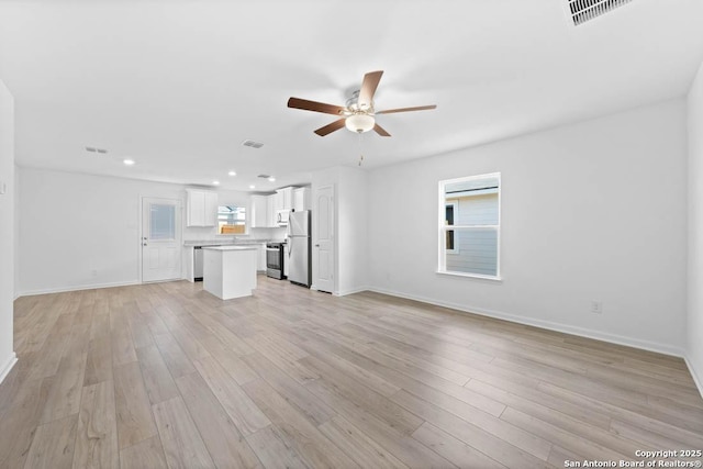 unfurnished living room with ceiling fan and light hardwood / wood-style floors