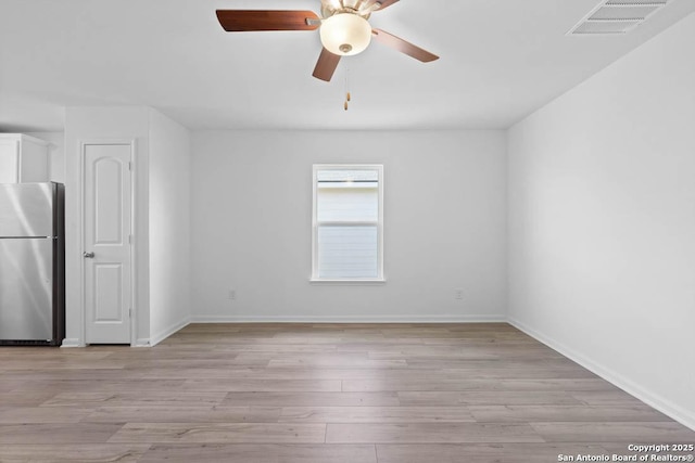 empty room with light hardwood / wood-style floors and ceiling fan