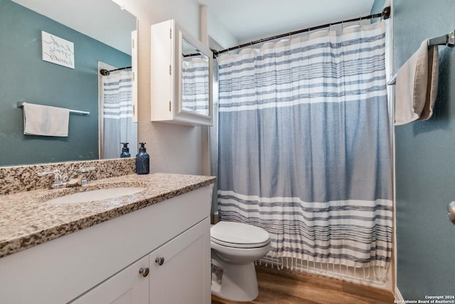 bathroom with vanity, toilet, curtained shower, and hardwood / wood-style floors