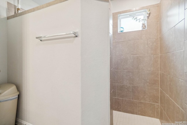 bathroom with tiled shower and toilet