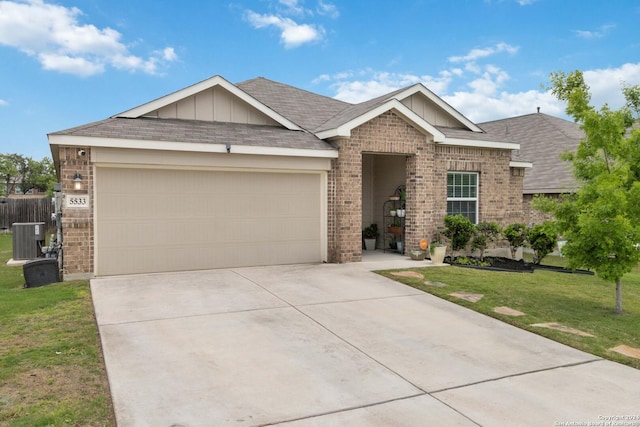 view of front of property with a garage, a front lawn, and central air condition unit