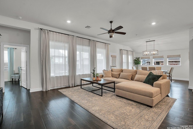 living room featuring dark hardwood / wood-style flooring, ceiling fan with notable chandelier, and lofted ceiling