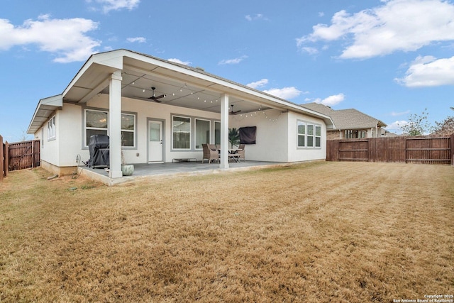 back of house featuring a lawn, a patio, and ceiling fan