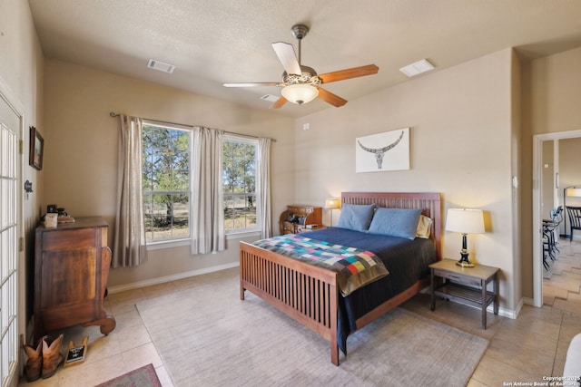 tiled bedroom featuring ceiling fan and a textured ceiling